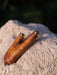 Wooden tool with gold accents on a textured surface