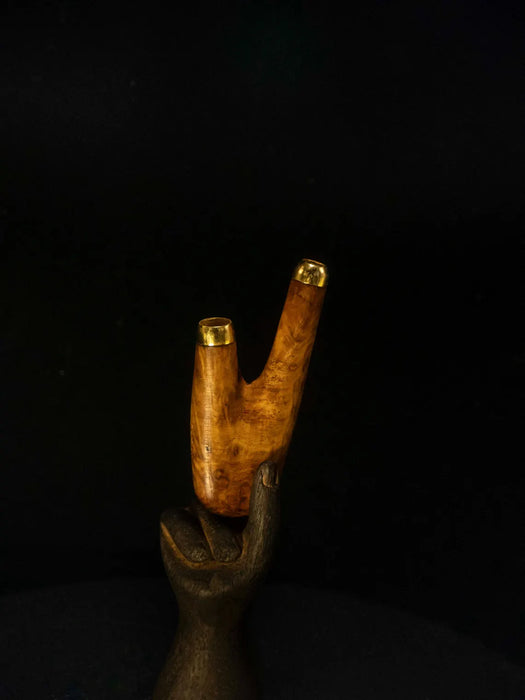 Wooden walking cane with a hand holding it against a black background