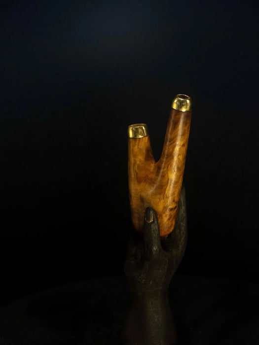 Wooden object with gold accents on a black background