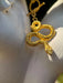 Gold snake-shaped earring on a person's ear