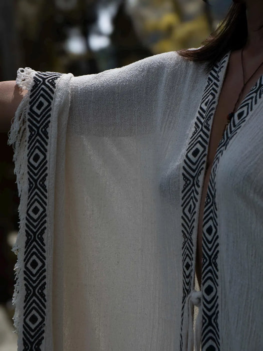 White garment with black geometric patterns on a blurred background