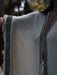 White garment with black geometric patterns on a blurred background
