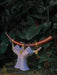 Decorative sculpture of hands holding a bow with a dark green leafy background