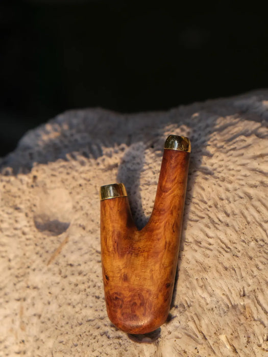 Wooden hunting call with gold accents on a wooden surface