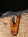 Wooden hunting call with gold accents on a wooden surface