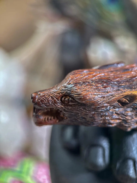 Close-up of a detailed wooden figurine of a creature with a blurred background