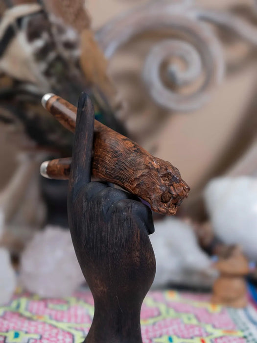 Wooden hand holding a rusted metal object with a blurred background