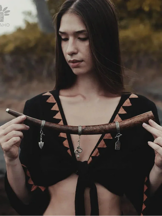 Woman holding a wooden object with a blurred natural background