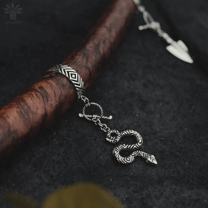Silver bracelet with a snake-shaped charm on a dark textured surface