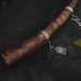 Silver bracelet with a pendant on a wooden stick against a dark background