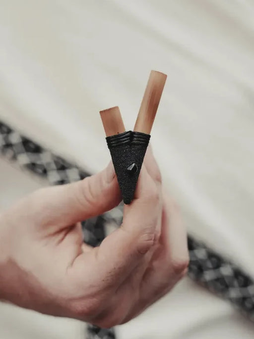 Hand holding two lip liners against a blurred background