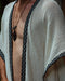 A man stands in a forest, his demeanor calm and grounded, wearing a Boho tribal cotton poncho, embodying a unisex, earthy shamanic style.