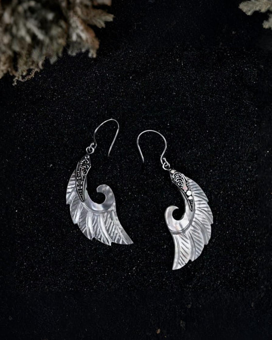 Exquisite Angel Wings earrings, crafted from lustrous mother-of-pearl and detailed sterling silver, radiating aesthetic grace and ethereal charm