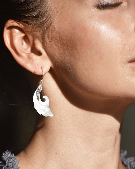Exquisite Angel Wings earrings, crafted from lustrous mother-of-pearl and detailed sterling silver, radiating aesthetic grace and ethereal charm
