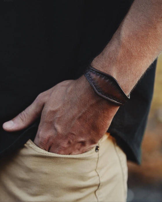 Handcrafted dark buffalo leather bracelet with a sculptural triple-infinity design, symbolizing eternal flow and masculine strength