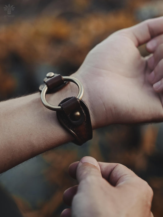 Dark buffalo leather bracelet with triple-infinity design — embodies life cycles, eternal flow, and inner harmony