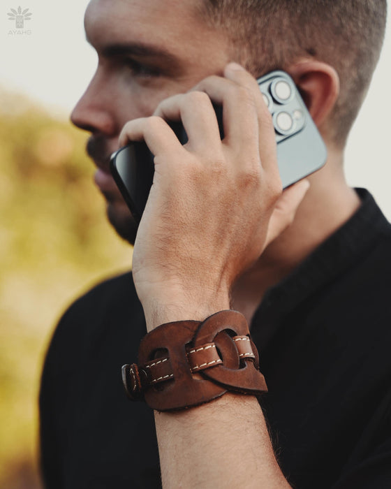 Handcrafted leather cuff with a triple-infinity symbol, designed for men who seek symbolic, meaningful accessories.
