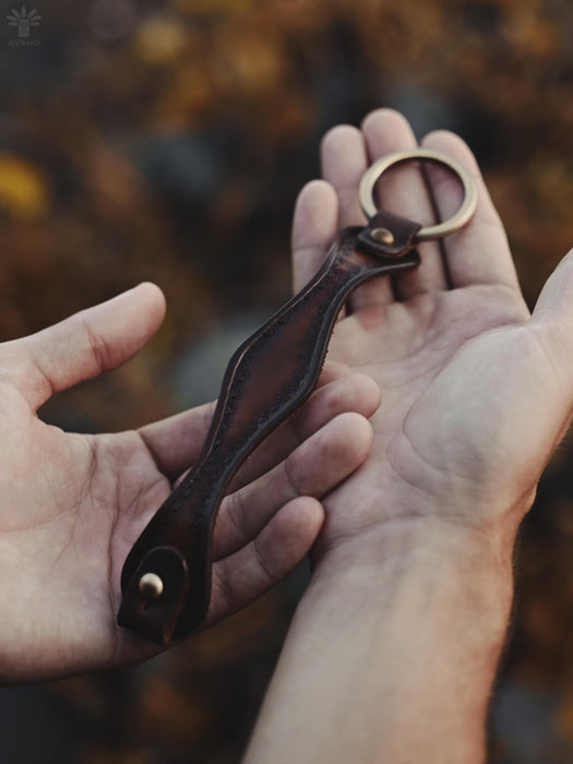 Rich dark buffalo leather bracelet with a triple-infinity symbol, embodying sacred masculine energy and balance.