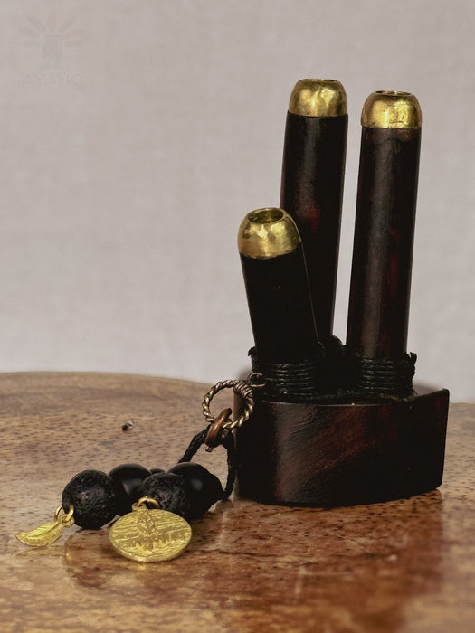 Black and gold decorative item on a wooden surface with a neutral background