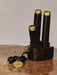 Black and gold decorative item on a wooden surface with a neutral background