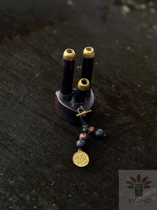 Small wooden object with gold accents and beads on a dark surface, featuring the AYAOH brand.