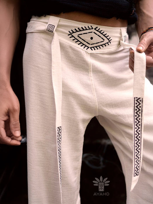 White pants with black patterns held by a person, featuring the Ayaho brand logo.