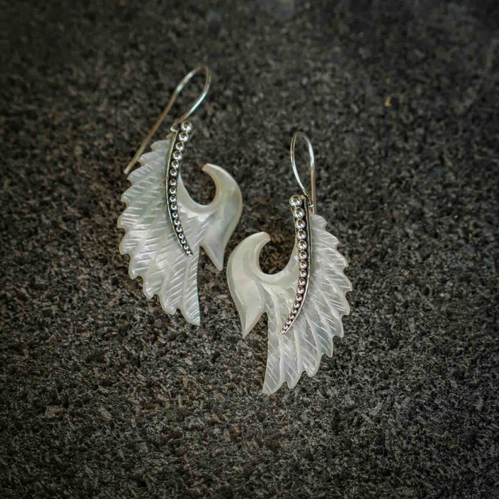 Exquisite Angel Wings  earrings, crafted from lustrous mother-of-pearl and detailed sterling silver, radiating aesthetic grace and ethereal charm