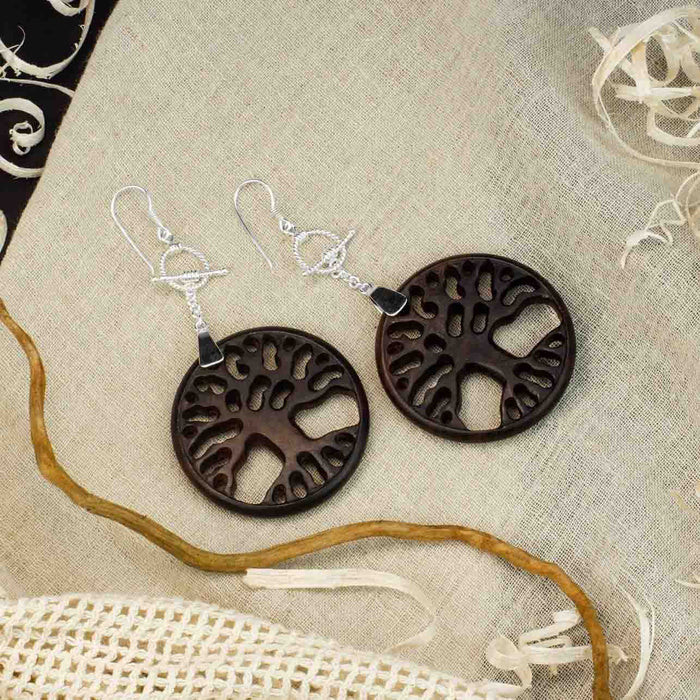 Woman adorned with a handcrafted rosewood and silver  Tree of Life pendant and matching earrings set, symbolizing spiritual unity and protection