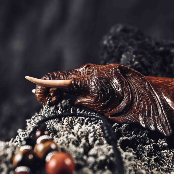 a wooden kuripe elephant pipe, designed for hape snuff application. The kuripe, linked to a charm-adorned necklace, serves as a unique, handmade smoking accessory and part of a shamanic protection kit, blending herbal medicine traditions