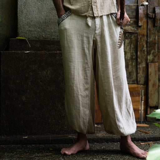 Close-up of unisex linen pants featuring a white hand-embroidered tribal pattern, embodying Boho and shamanic styles